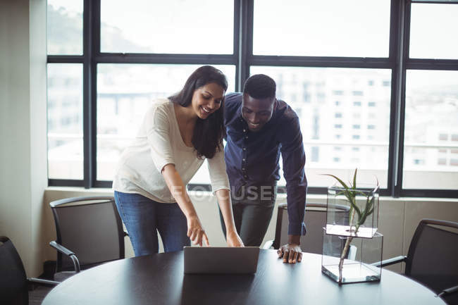 Empresário e um colega discutindo sobre laptop no escritório — Fotografia de Stock