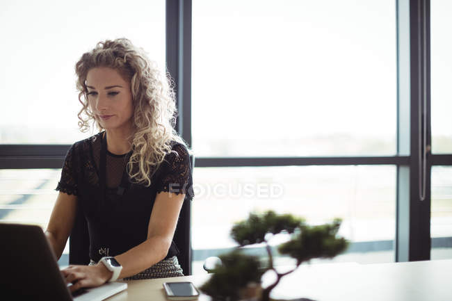 Businesswoman working on laptop in office — Stock Photo