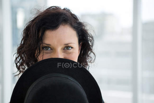 Portrait of dancer hiding her face with hat in the studio — Stock Photo