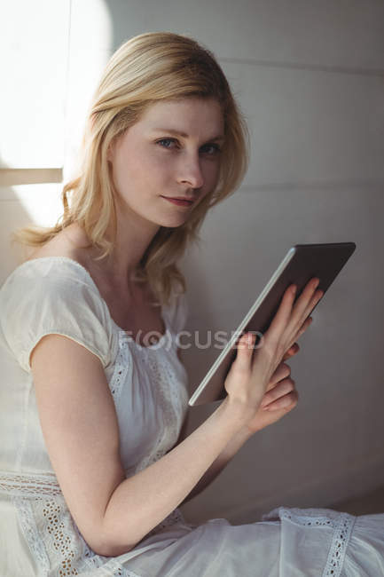 Портрет красивой женщины с помощью цифрового планшета дома — стоковое фото
