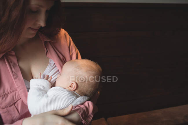 Мать кормит грудью ребенка в кафе, крупным планом — стоковое фото