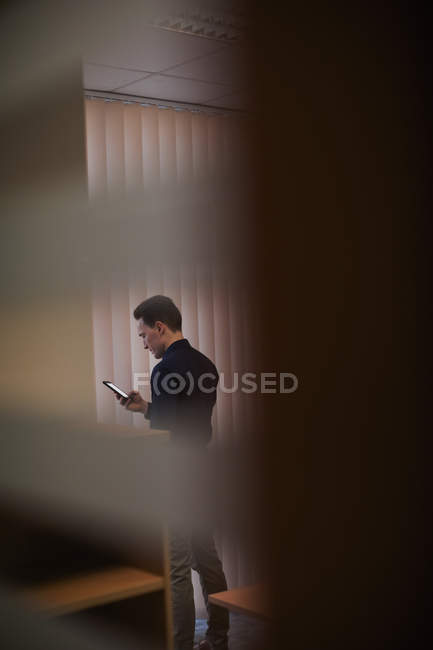 Executivo masculino usando telefone celular no escritório — Fotografia de Stock
