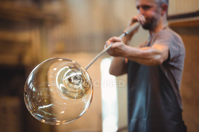 Glasbläser formen ein Glas auf dem Blasrohr in der Glasbläserei — Stockfoto