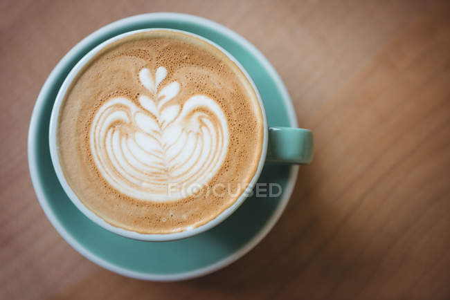Xícara de café com bela arte latte na mesa de madeira — Fotografia de Stock