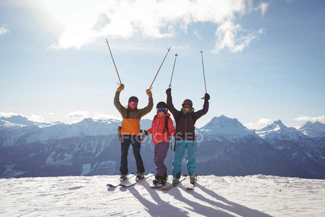 Feiernde Skifahrer stehen im Winter auf schneebedecktem Berg — Stockfoto