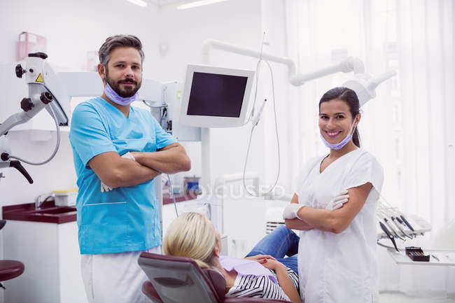 Portrait of male and female dentists standing with arms crossed in dental clinic — Stock Photo