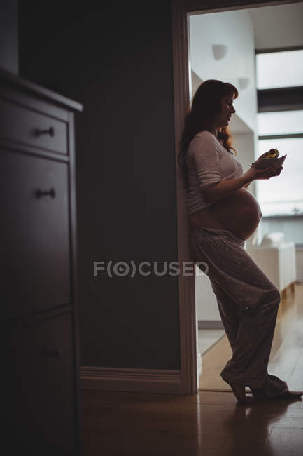 Беременная женщина завтракает дома — стоковое фото