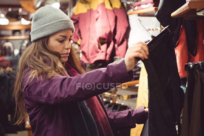 Женщина выбирает одежду в магазине одежды — стоковое фото