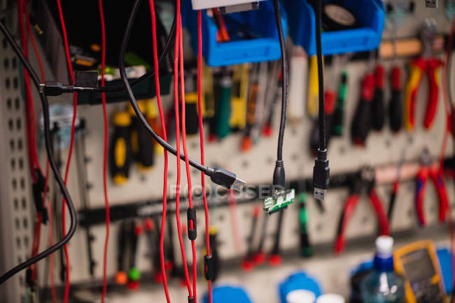 Divers câbles de données suspendus dans un centre de réparation — Photo de stock