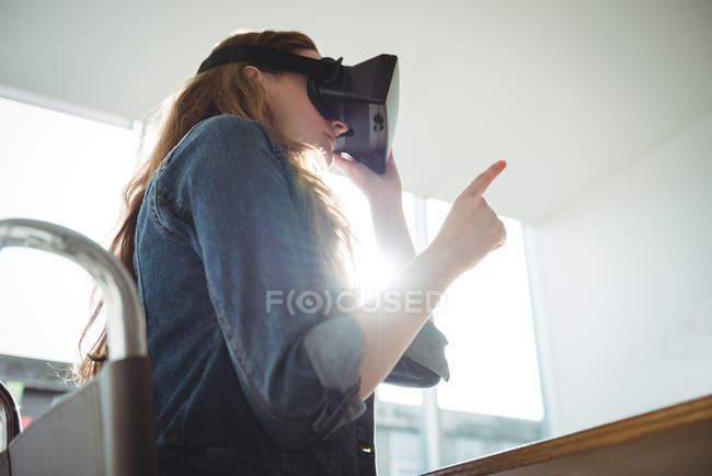 Представительница женского бизнеса, использующая гарнитуру виртуальной реальности в офисе — стоковое фото