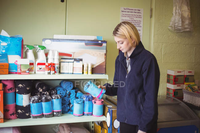 Woman choosing bath towel in shop at dog care center — Stock Photo