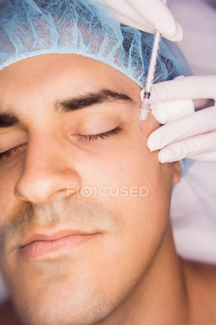 Man receiving botox injection on face at clinic — Stock Photo