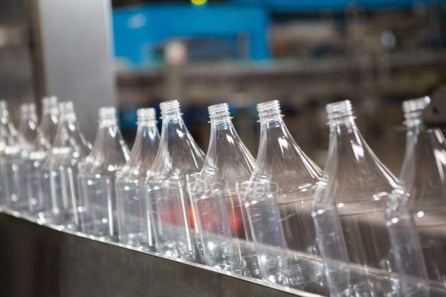 Row of empty bottles on production line in manufacturing industry — Stock Photo
