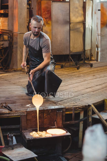 Glassblower working over a molten glass at glassblowing factory — Stock Photo