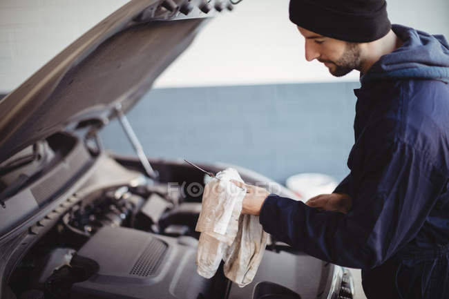 Main de mécanicien voiture d'entretien avec un outil au garage de réparation — Photo de stock