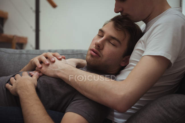 Romantisches homosexuelles Paar entspannt sich auf Sofa im Wohnzimmer zu Hause — Stockfoto