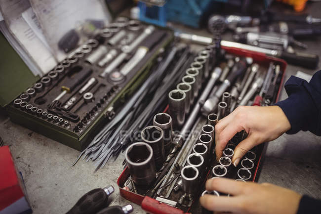Mani di meccanico femminile organizzare vari strumenti in garage di riparazione — Foto stock