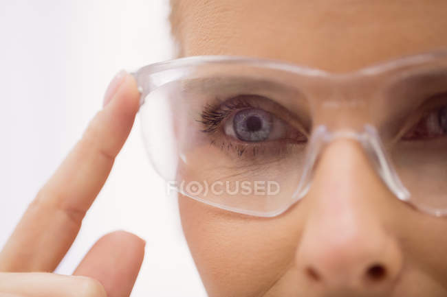 Крупный план женщины-врача в защитных очках в клинике — стоковое фото