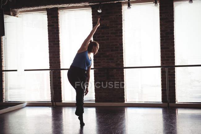 Jeune femme pratiquant la danse en studio de danse — Photo de stock