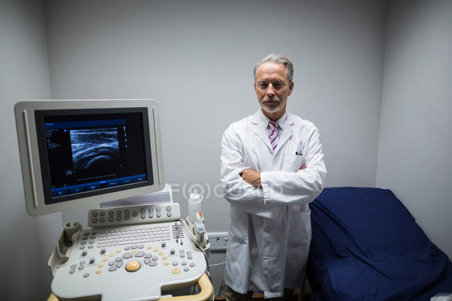 Портрет хірурга зі зброєю перетнув операційний ультразвуковий пристрій у лікарні — стокове фото