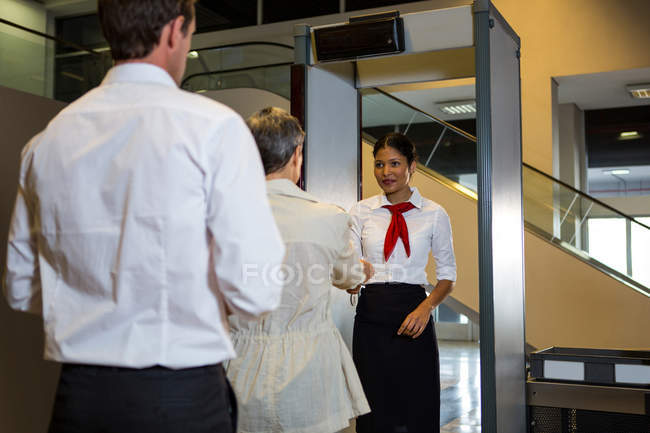 Вид ззаду жінки, що переносить посадковий талон на жіночий персонал — стокове фото