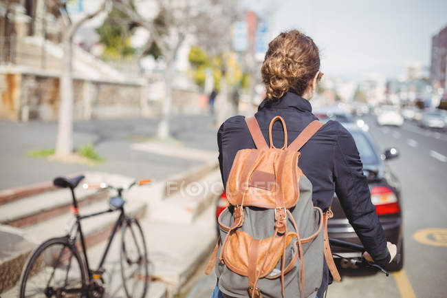 Вид ззаду жінки, що їде на велосипеді на дорозі — стокове фото