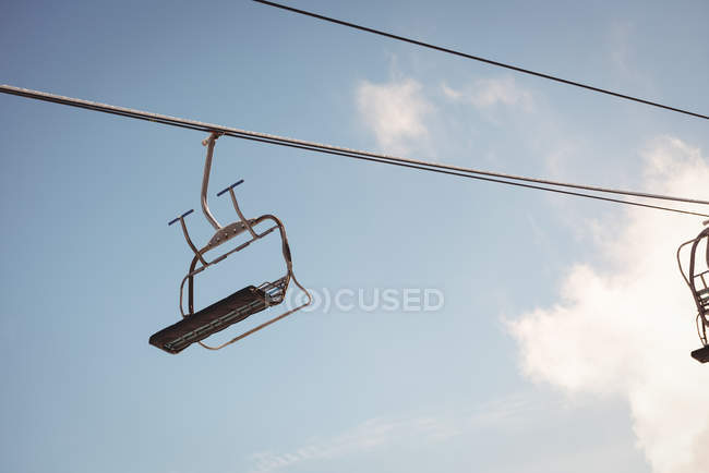 Elevador de esqui vazio na estância de esqui contra o céu azul — Fotografia de Stock