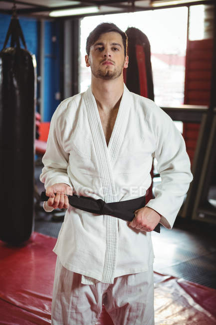Retrato del jugador de karate de pie en el gimnasio - foto de stock