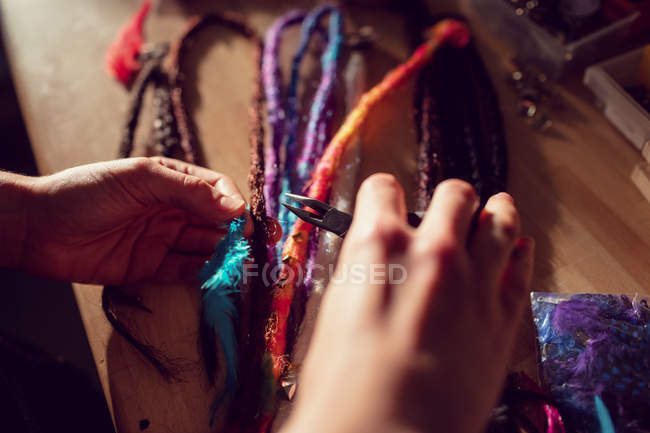 Close-up of female hairdresser working at desk in dreadlocks shop — Stock Photo