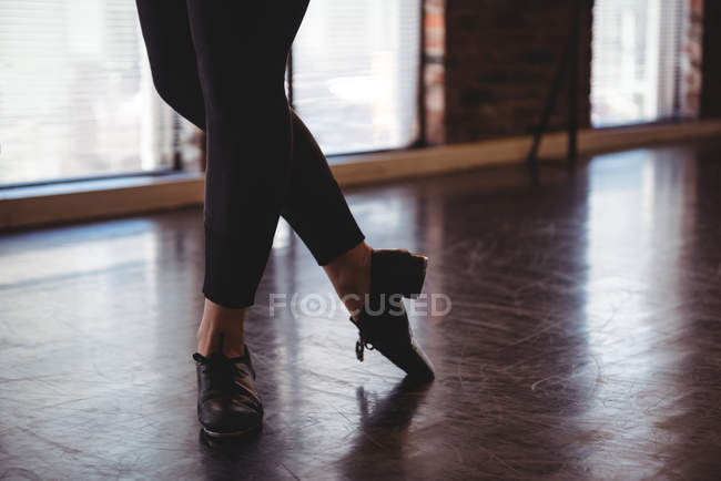 Ноги женщины, исполняющей танец в балетной студии — стоковое фото