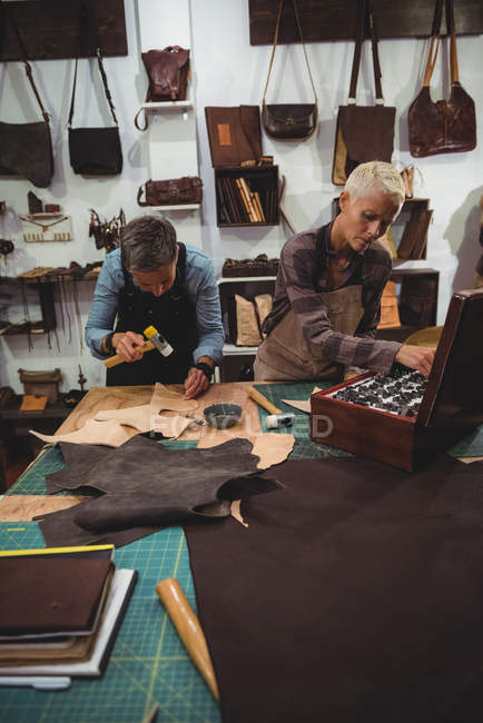 Artisans attentifs marteler le cuir dans l'atelier — Photo de stock