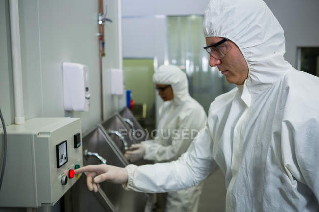 Close-up of technicians operating machine at meat factory — Stock Photo
