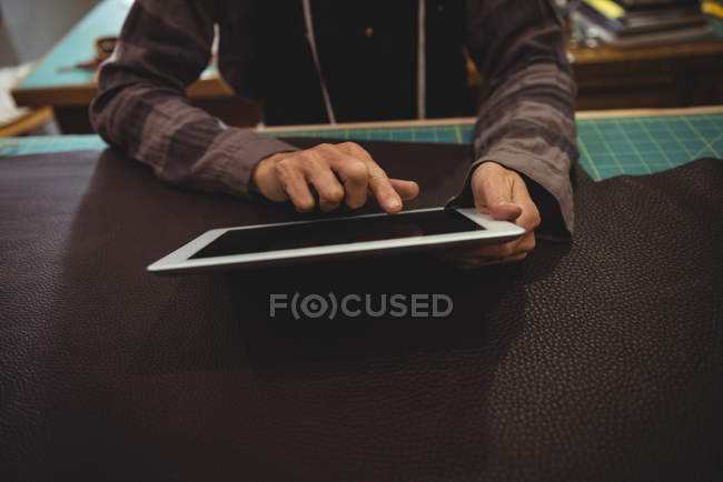 Mid-section of craftswoman using digital tablet in workshop — Stock Photo