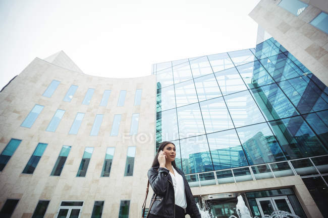 Femme parlant sur un téléphone portable à l'extérieur des locaux du bureau — Photo de stock
