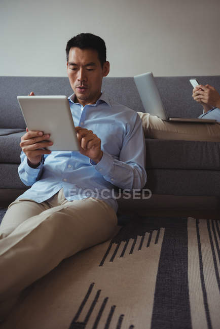Uomo che utilizza tablet digitale in salotto a casa — Foto stock