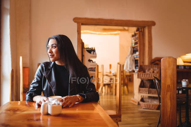 Mulher atenciosa tomando uma xícara de café no café — Fotografia de Stock