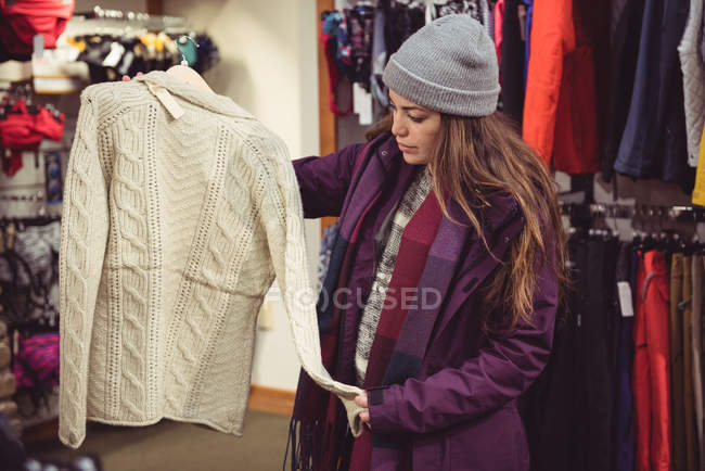 Donna che seleziona abbigliamento in un negozio di abbigliamento — Foto stock