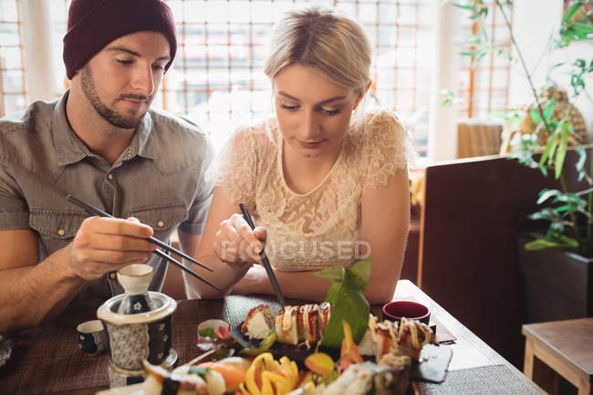 Giovane coppia con sushi nel ristorante — Foto stock