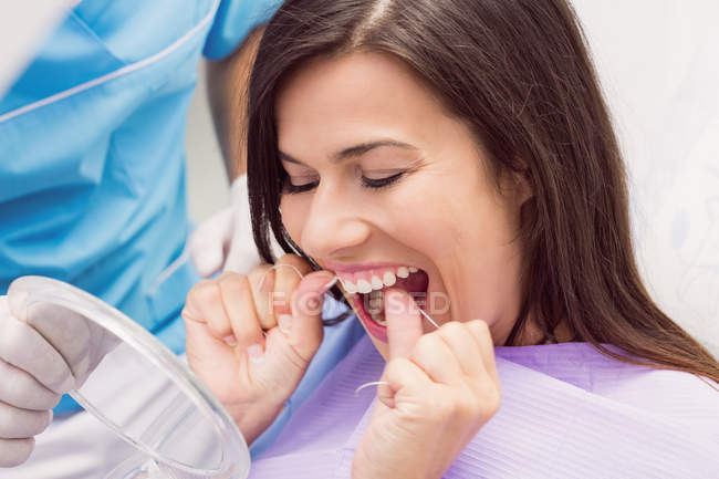 Denti con filo interdentale di paziente femminile in clinica dentale — Foto stock