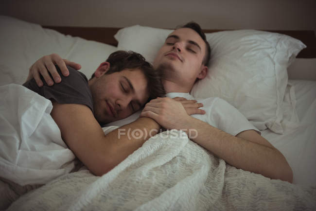 Homosexuell paar umarmen, während schlafen auf Bett im Schlafzimmer — Stockfoto