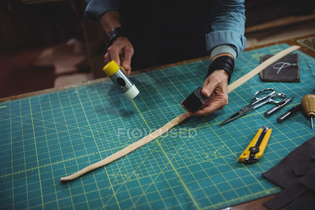 Mittelteil der Handwerkerin hämmert Leder in Werkstatt — Stockfoto