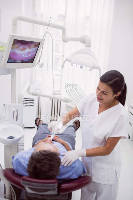Odontoiatra che visita la paziente in clinica dentistica — Foto stock