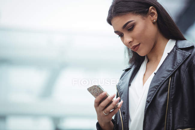 Femme utilisant un téléphone portable à l'extérieur des locaux du bureau — Photo de stock