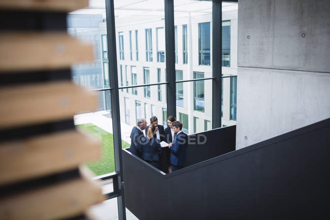 Grupo de empresários tendo uma discussão perto de escadaria no escritório — Fotografia de Stock