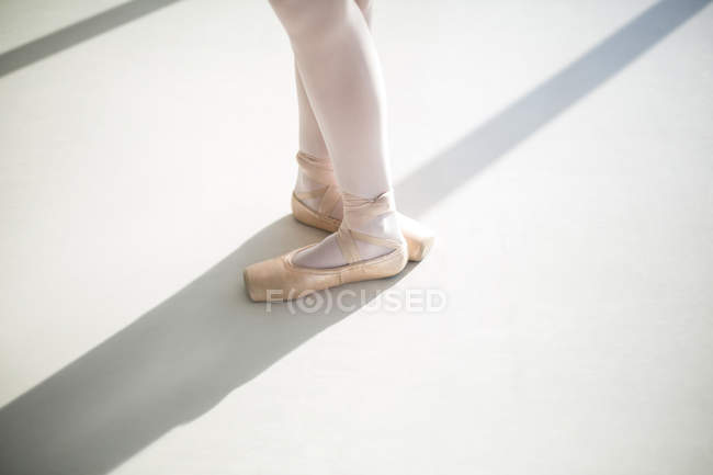Feet of ballet dancer performing ballet dance in the ballet studio — Stock Photo