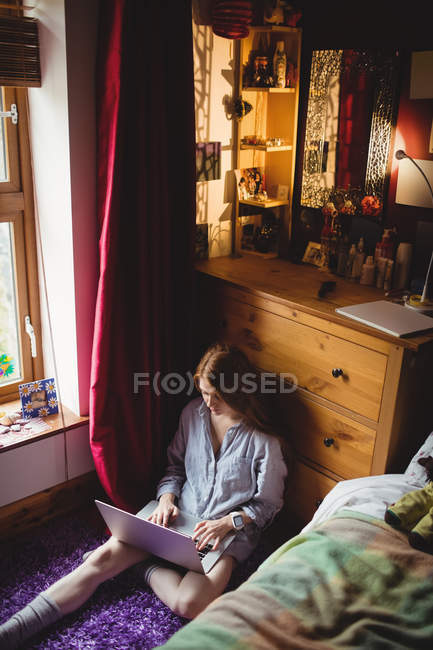 Mulher bonita usando laptop no quarto em casa — Fotografia de Stock