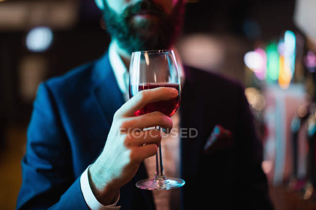 Sezione media di uomo d'affari che beve un bicchiere di vino al bar — Foto stock