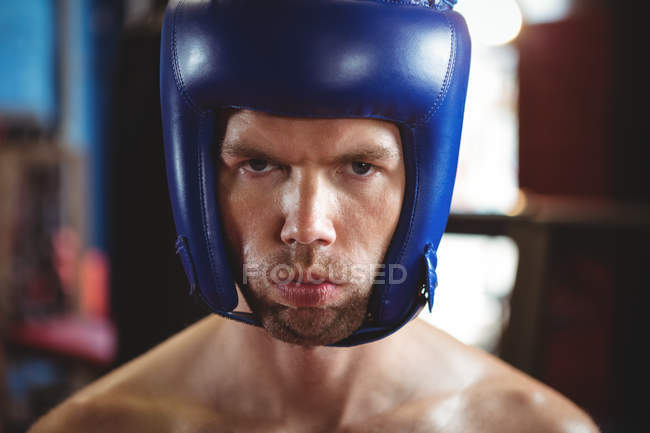 Portrait of boxer wearing boxing headgear in fitness studio — Stock Photo
