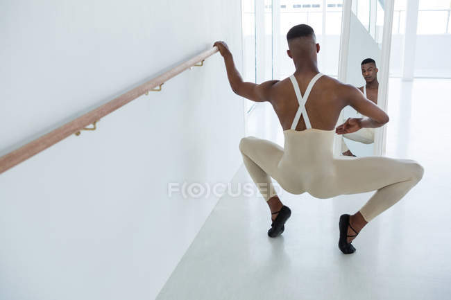 Балерино практикует балет перед зеркалом в студии — стоковое фото