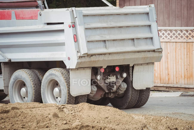 Camión volquete por montón de barro en el sitio de construcción - foto de stock